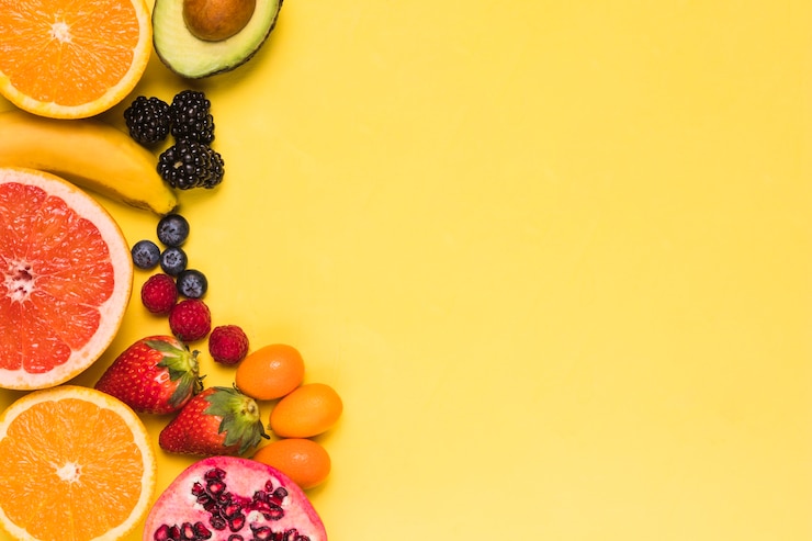 Photo gratuit fruits et baies tranchés sur fond jaune