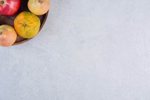 Fruits biologiques frais. Mandarine juteuse et poires sur plaque en bois.