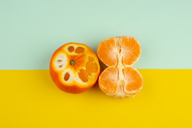 Fruits frais mandarine orange aigre moelleux sur fond bleu-jaune