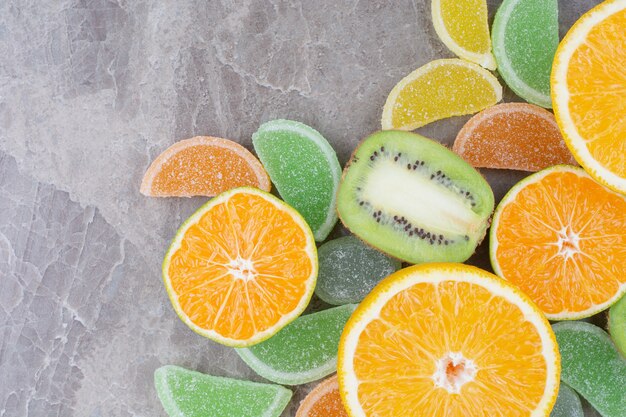 Fruits frais avec des marmelades sucrées sur fond de marbre.