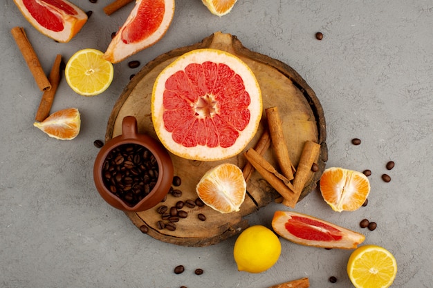 Fruits avec des graines de café et de la cannelle sur le bureau en bois et le sol gris