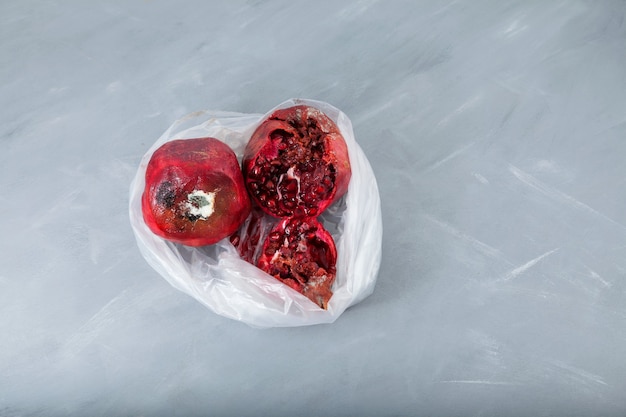 Fruits de grenade gâtés pourris dans un sac en plastique