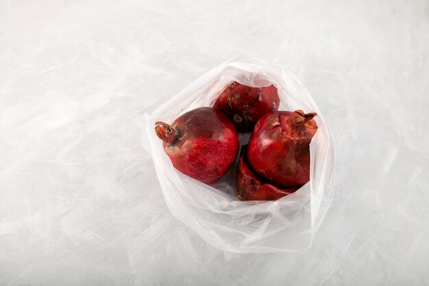 Fruits de grenade pourris gâtés dans un sac en plastique fruits laids moisis réduction des déchets organiques
