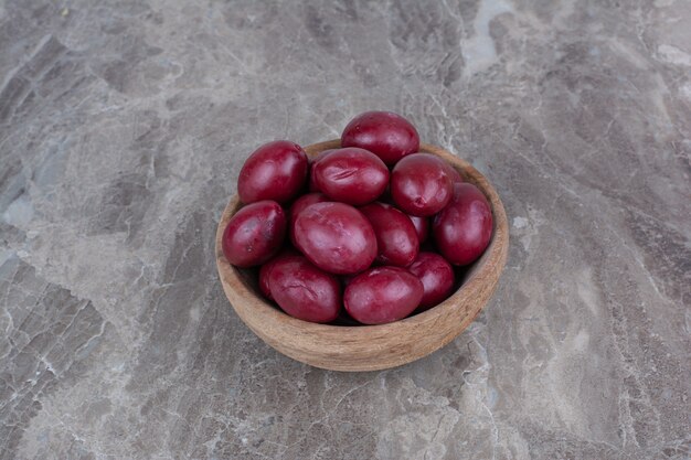 Fruits marinés maison dans un bol en bois.