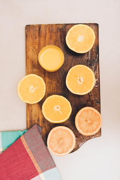 Fruits orange coupées en deux sur une planche à découper et serviette en toile de fond blanc