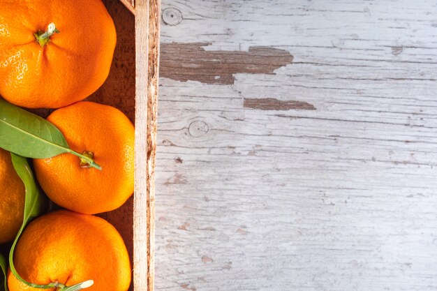 Fruits orange dans une vue de dessus de boîte en bois avec surface en bois espace copie