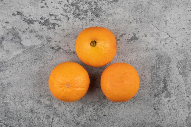 Fruits oranges frais isolés sur table en pierre.