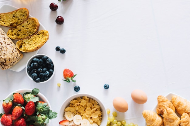 Photo gratuite fruits; pain cuit au four et croissant sur fond blanc