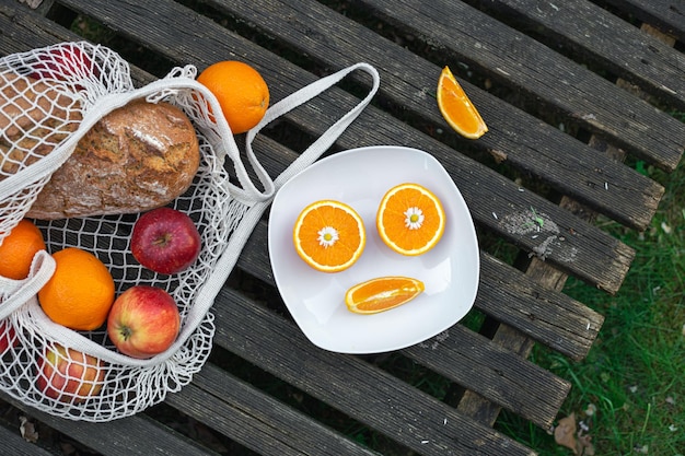 Photo gratuite fruits et pain dans un sac à provisions sur un fond en bois