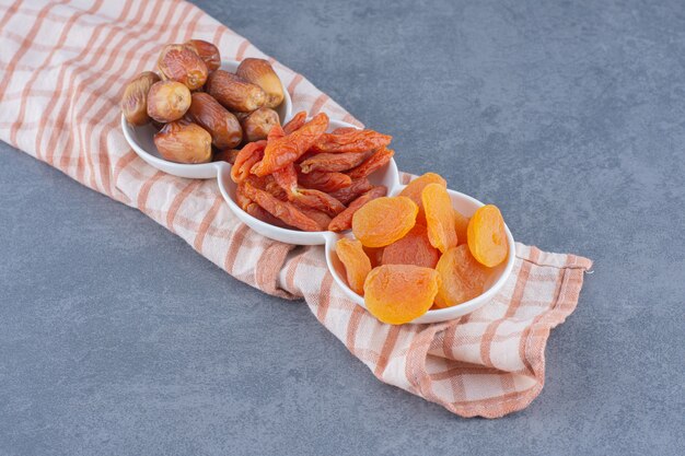 Des fruits secs dentelés sur la serviette, sur le fond de marbre.