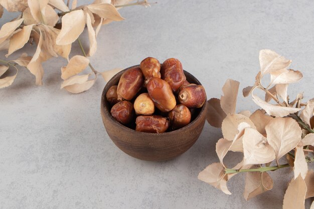 Fruits secs et feuilles dentelées sur la surface bleue