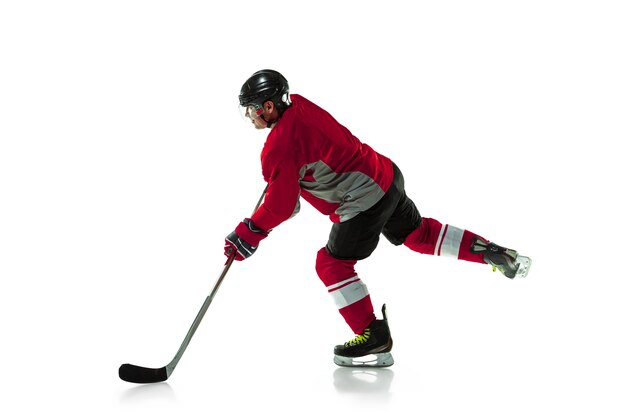 En fuite. Joueur de hockey masculin avec le bâton sur un court de glace et un mur blanc. Sportif portant de l'équipement et un casque pratiquant. Concept de sport, mode de vie sain, mouvement, mouvement, action.