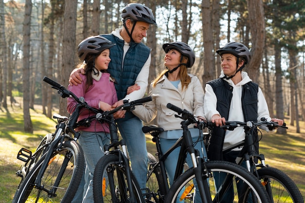 Full shot famille faisant du vélo ensemble