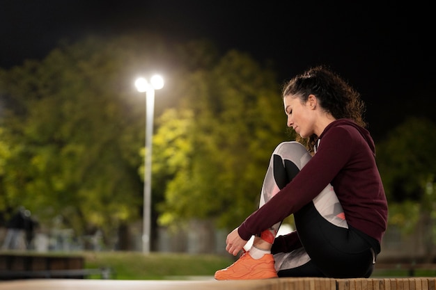 Full shot femme assise sur un banc