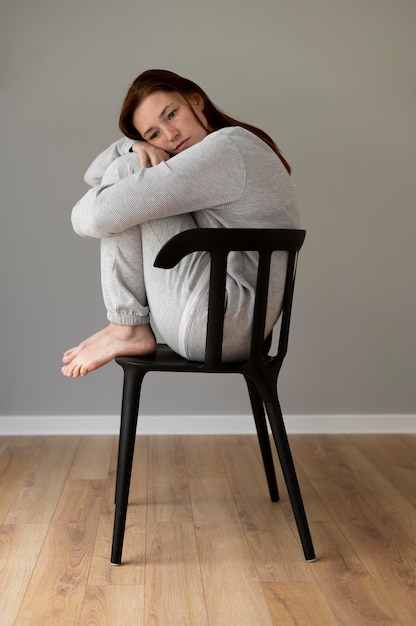 Full shot femme assise sur une chaise