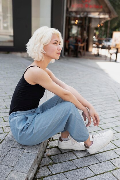 Full shot femme assise en plein air