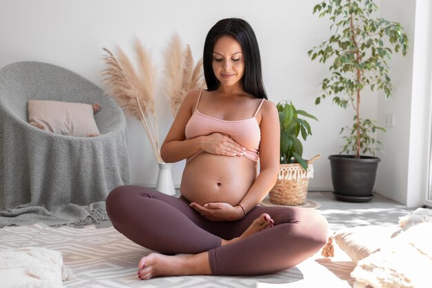 Full shot femme enceinte assise