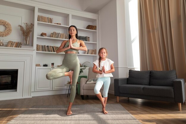 Full shot femme et enfant debout sur une jambe