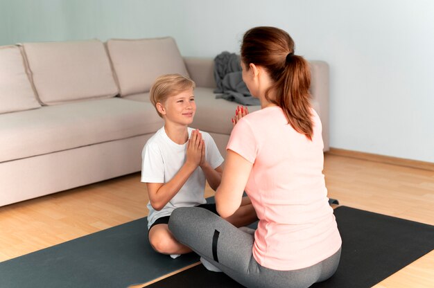 Full shot femme et enfant sur tapis de yoga