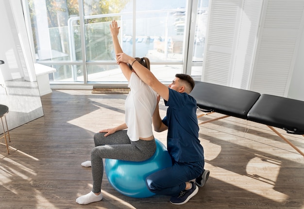 Full shot femme exerçant sur ballon de gym