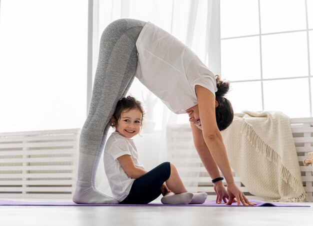 Full shot femme qui s'étend avec enfant