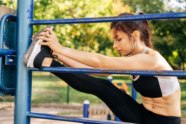 Full shot femme qui s'étend des jambes