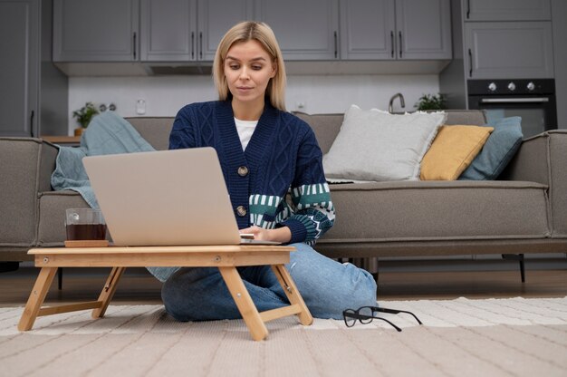 Full shot femme travaillant sur ordinateur portable