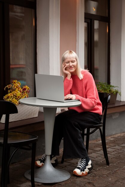 Full shot femme travaillant sur ordinateur portable