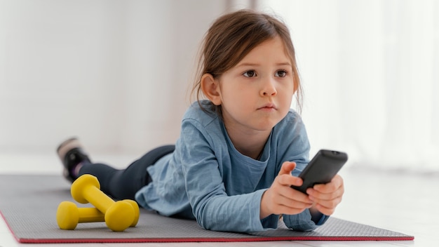 Full shot girl holding remote