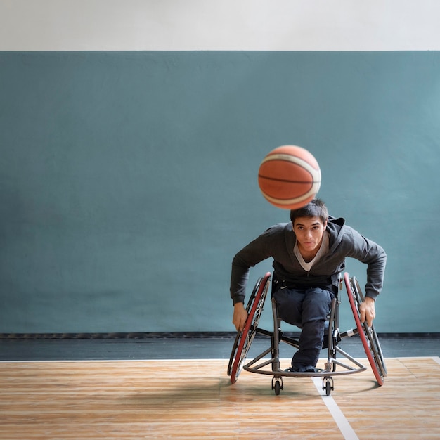 Full shot homme en fauteuil roulant jouant au jeu