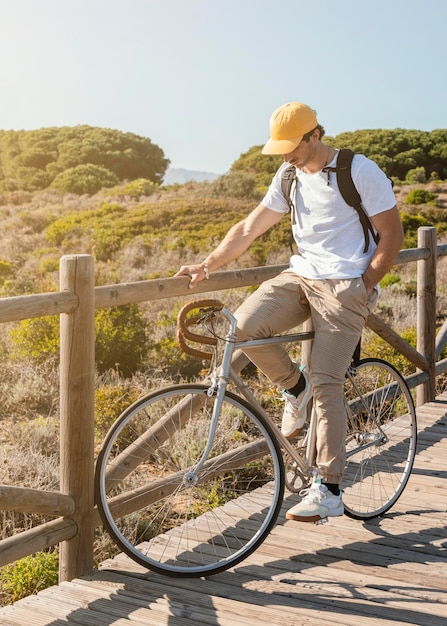 Full shot homme posant sur vélo