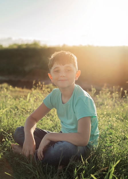 Full shot kid assis sur l'herbe