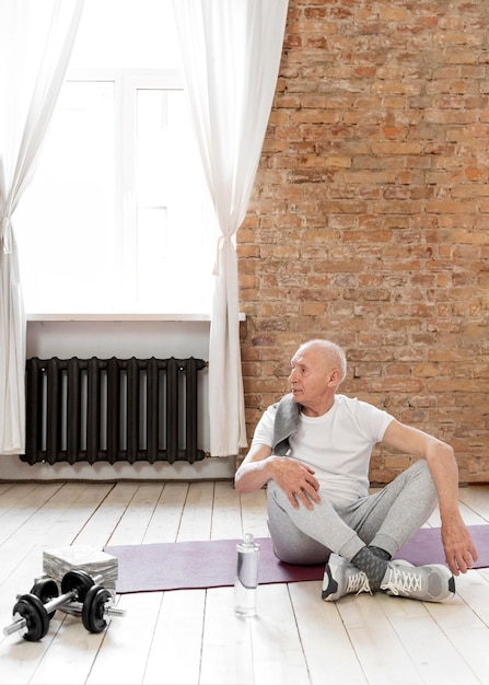 Full shot senior man sur tapis de yoga