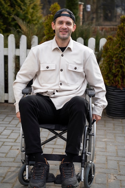 Full shot smiley homme handicapé à l'extérieur