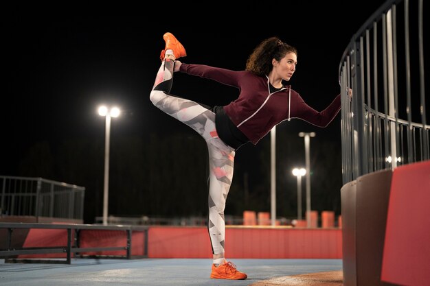 Full shot woman stretching jambe