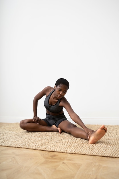 Full shot woman stretching jambe