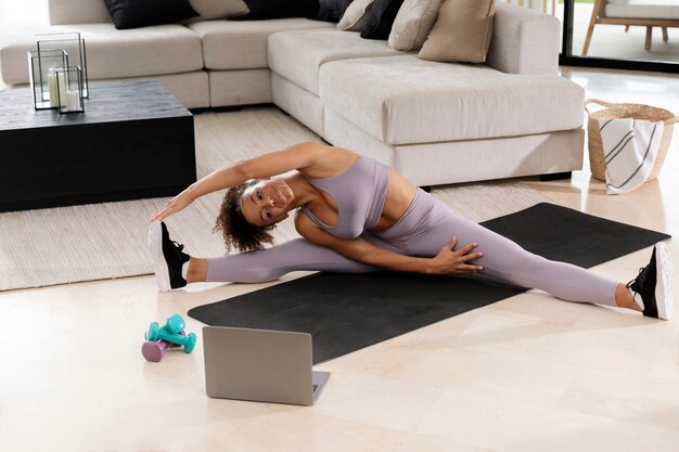 Full shot woman stretching sur tapis