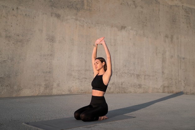 Photo gratuite full shot woman stretching sur tapis