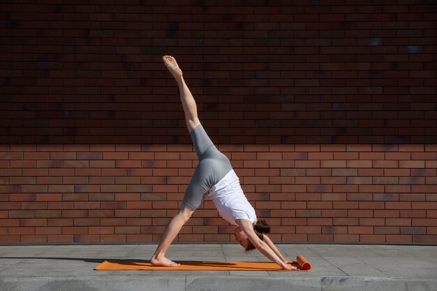 Full shot woman stretching sur tapis