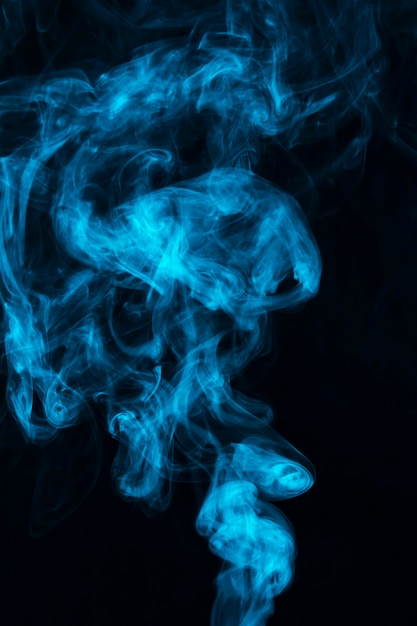 La fumée bleue se propage sur fond noir
