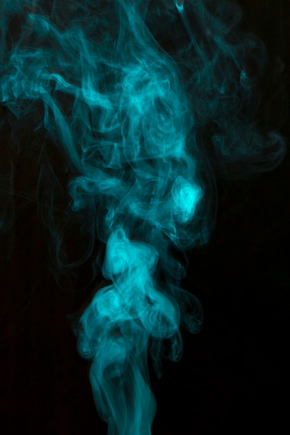 Fumée bleue vaporeuse répandue sur fond noir