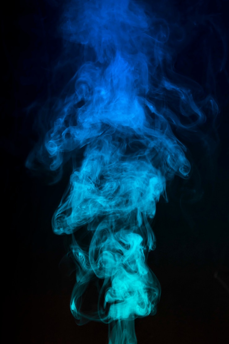 Photo gratuit fumée teintée bleue répandue sur fond noir