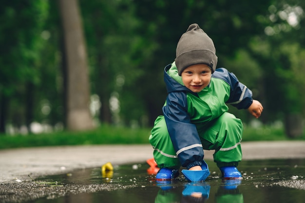 Funny Kid En Bottes De Pluie Jouant Dans Un Parc De Pluie