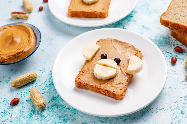 Photo gratuite funny sandwich à l'ours et au singe avec beurre d'arachide, banane et cassis, vue de dessus