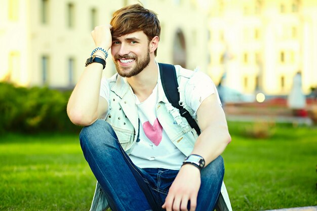 Funny smiling hipster bel homme beau en tissu d'été élégant dans la rue en lunettes de soleil