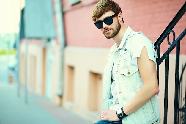 Photo gratuite funny smiling hipster bel homme beau en tissu d'été élégant dans la rue en lunettes de soleil