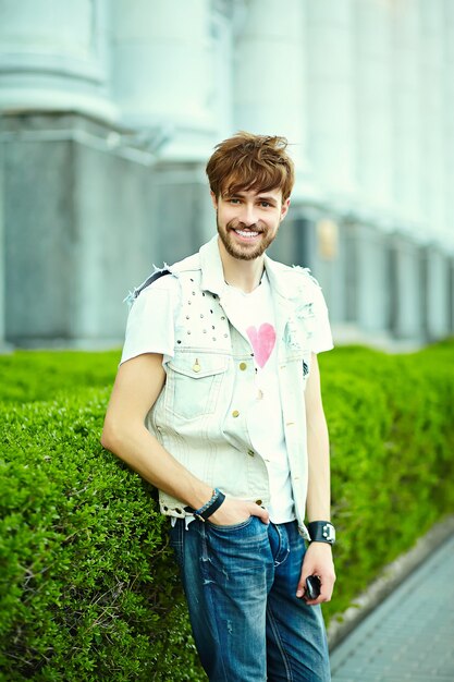 Funny smiling hipster bel homme beau en tissu d'été élégant dans la rue en lunettes de soleil