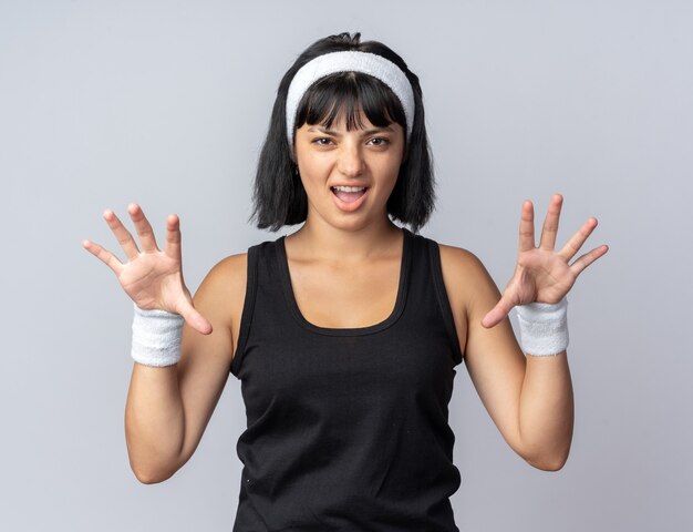 Funny young fitness girl wearing headband looking at camera effrayant faisant des gestes de griffes comme un chat