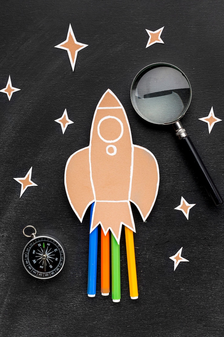 Photo gratuit fusée de retour à l'école avec loupe et crayons