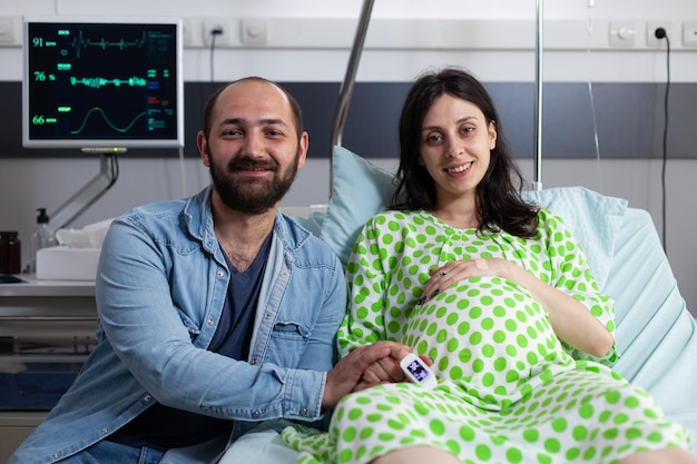 Photo gratuite des futurs parents joyeux se préparent à l'accouchement dans une salle d'hôpital, attendant que le médecin vienne et commence une césarienne.